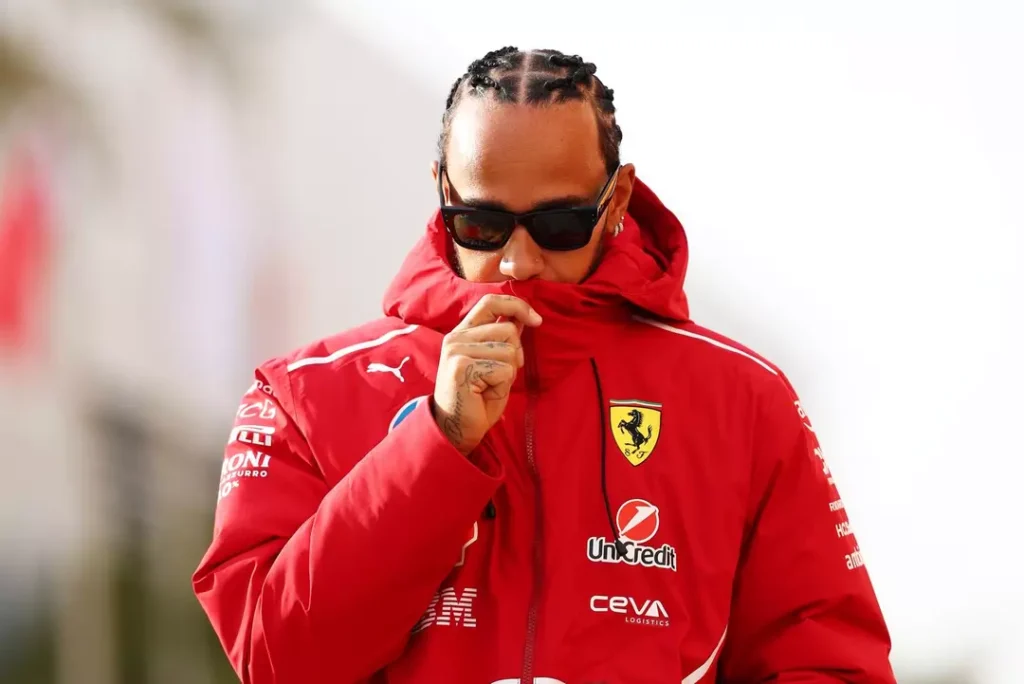Lewis Hamilton vestindo jaqueta vermelha da Ferrari durante atividades da Fórmula 1, imagem que ilustra a diferença entre Schumacher e Hamilton, destacando o estilo moderno, a postura reservada e a nova fase do heptacampeão na equipe italiana.