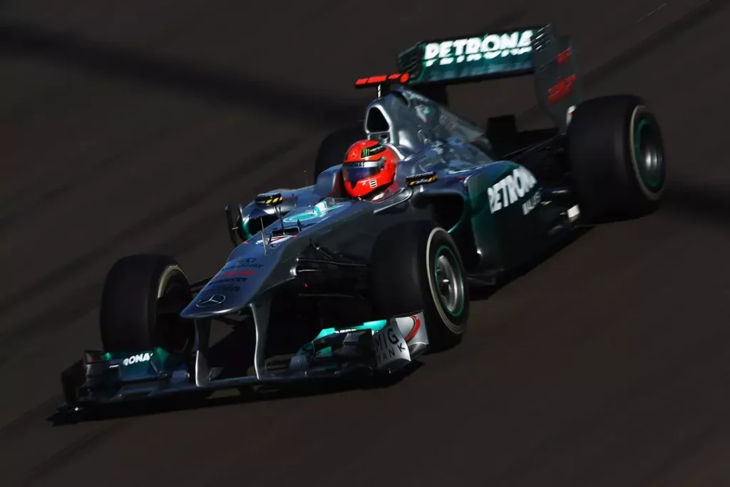 Michael Schumacher pilotando um carro da Mercedes na Fórmula 1, imagem que representa a diferença entre Schumacher e Hamilton, destacando o estilo agressivo de pilotagem, a era dominante do alemão e sua fase final na categoria.