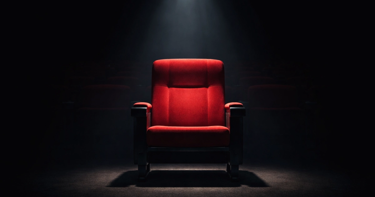 Assento vermelho iluminado por um único feixe de luz em ambiente escuro, destacando visualmente o conceito de lugar para sentar e ilustrando a diferença entre acento e assento.