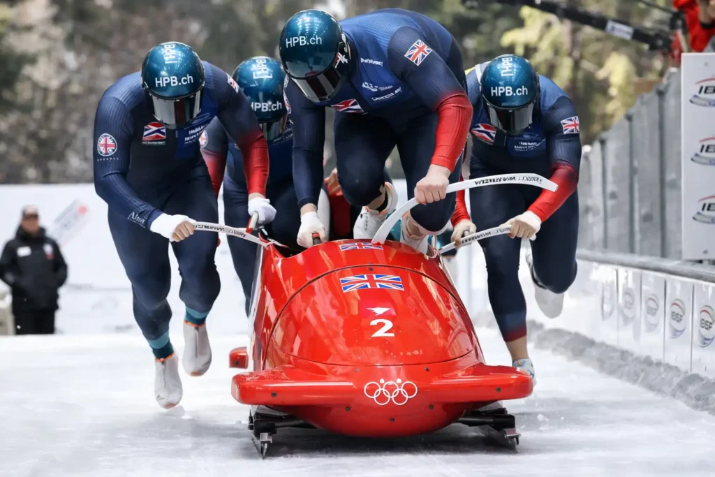 Equipe de bobsleigh empurrando trenó na largada olímpica, exemplo para entender qual é a diferença entre bobsleigh, skeleton e luge.