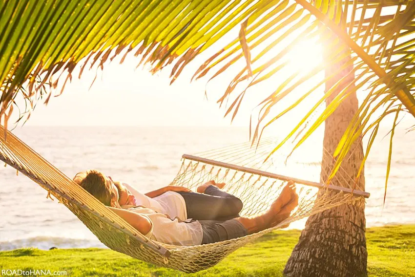 Casal relaxando em uma rede à beira-mar no Havaí, simbolizando o estilo de vida tranquilo das ilhas e ajudando a ilustrar qual é a diferença de fuso horário no Havaí.