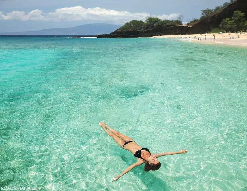 Pessoa relaxando no mar cristalino de uma praia do Havaí, representando o ritmo tranquilo das ilhas e ajudando a contextualizar qual é a diferença de fuso horário no Havaí.