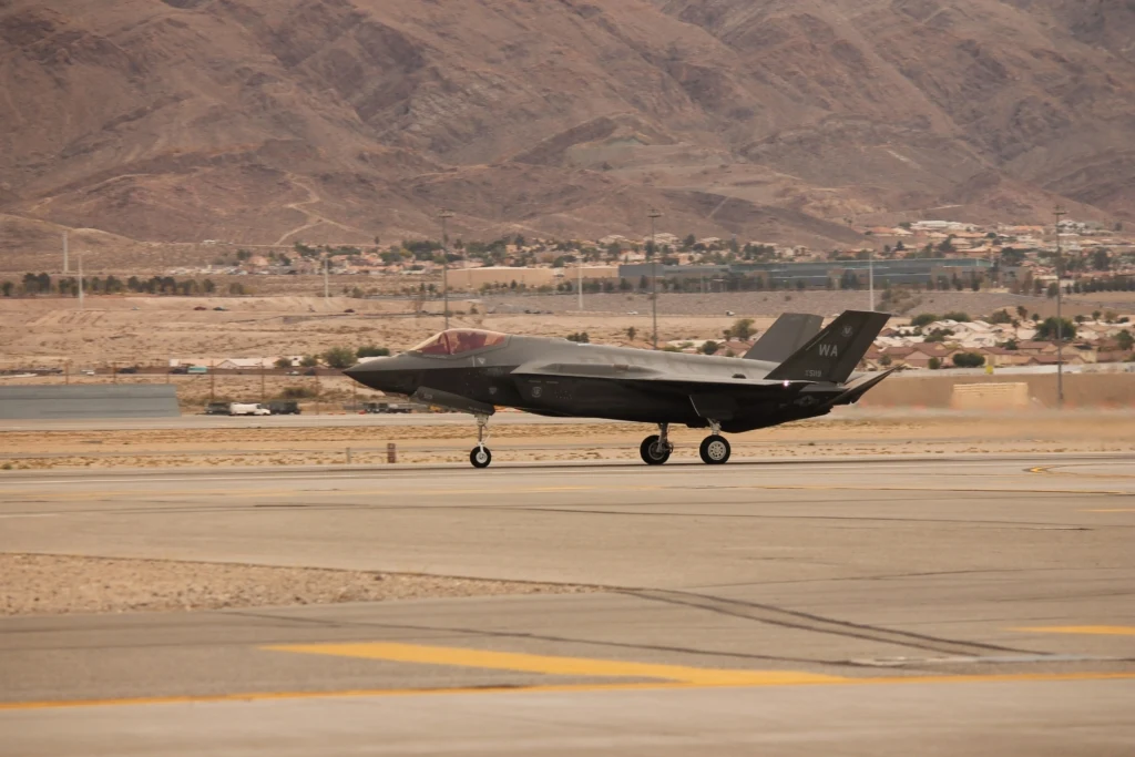 Caça F-35A Lightning II taxiando na pista em base aérea desértica, destacando a diferença entre as diferentes variantes do Lockheed Martin F-35 e sua configuração de decolagem convencional (CTOL).