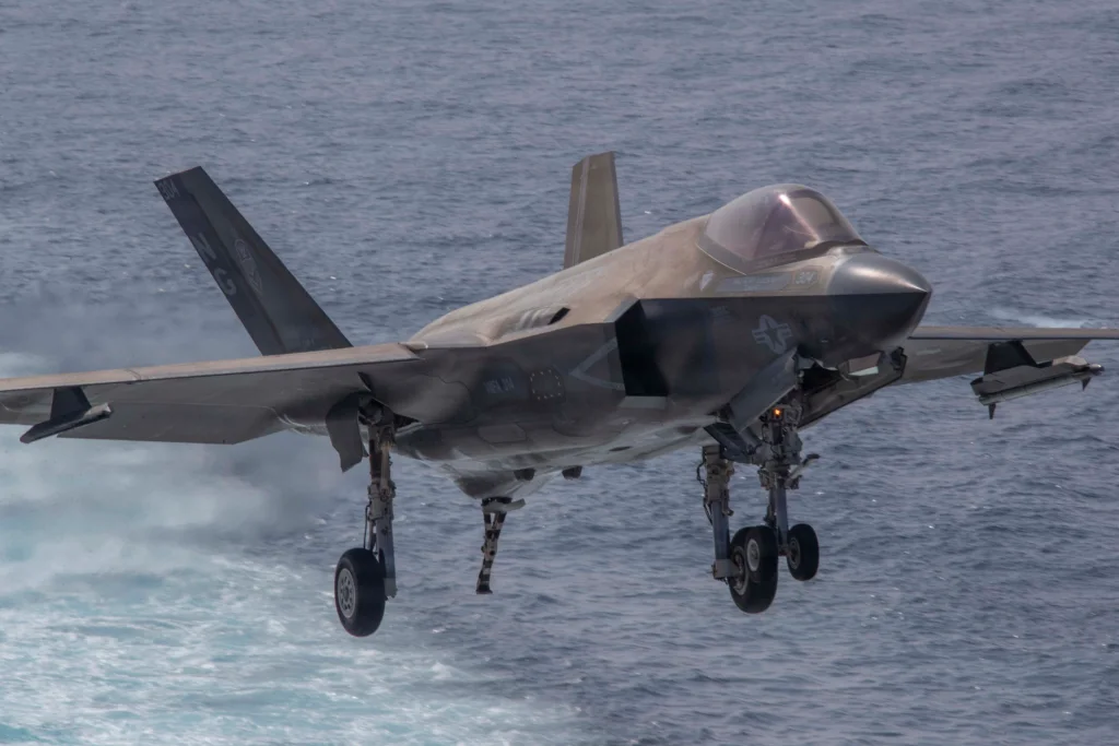 F-35C Lightning II aproximando-se para pouso em porta-aviões sobre o mar, evidenciando a diferença entre as diferentes variantes do Lockheed Martin F-35 e sua configuração naval com trem de pouso reforçado e asas maiores.