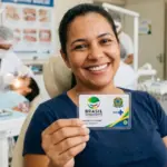 Mulher sorridente sentada em um consultório odontológico do SUS segurando em destaque o cartão do programa Brasil Sorridente. Ao fundo, um dentista realiza atendimento em outro paciente, reforçando o ambiente de saúde pública humanizada.